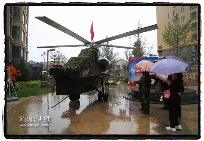 小區(qū)突然出現(xiàn)“飛機(jī)坦克”，其中殲15艦載戰(zhàn)斗機(jī)一架、99式主戰(zhàn)坦克一輛、武直-10武裝直升機(jī)一架，吸引了眾多市民雨中圍觀、合影。